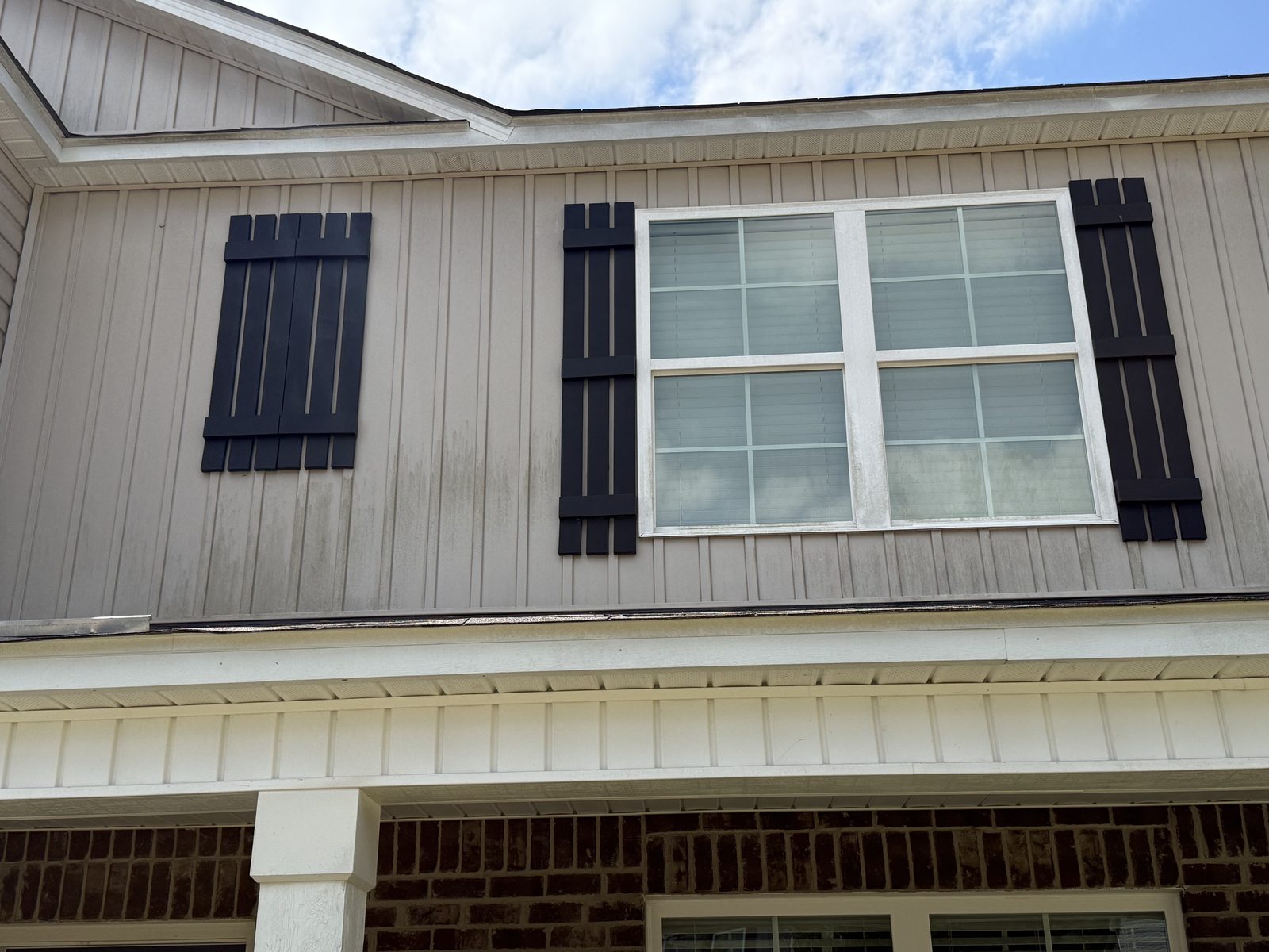 Before - Board and batten siding with algae streaks and staining near shutters